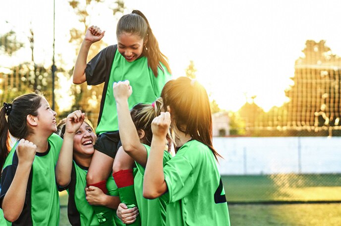 El logotipo de ACTIV-GO® sobre una imagen de un equipo deportivo femenino que levanta a una de sus jugadoras.