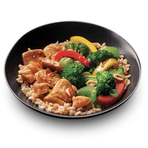 A black bowl filled with Kung Pao Chik'n loaded with broccoli, peanuts, and red and yellow peppers.
