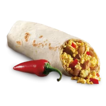 A red pepper beside a Big Sur Breakfast Burrito cut in half to show potatoes, red pepper, and tofu.