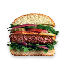 An Awesome Burger cut in half topped with lettuce, tomatoes, pickles, and onion.