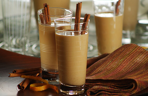 Glasses of Chilean Cola de Mono with cinnamon sticks beside a folded cloth placemat.