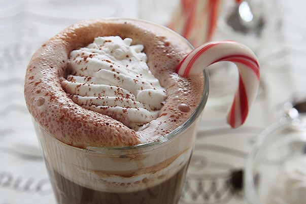 A frothy peppermint mocha with whipped cream and a candy cane.