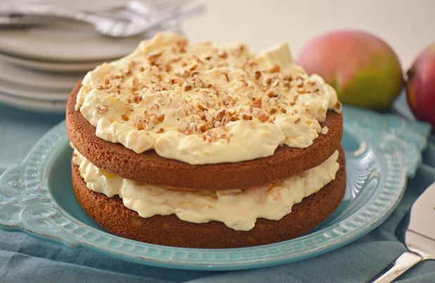 A two layer cake with whipped mango frosting between layers.