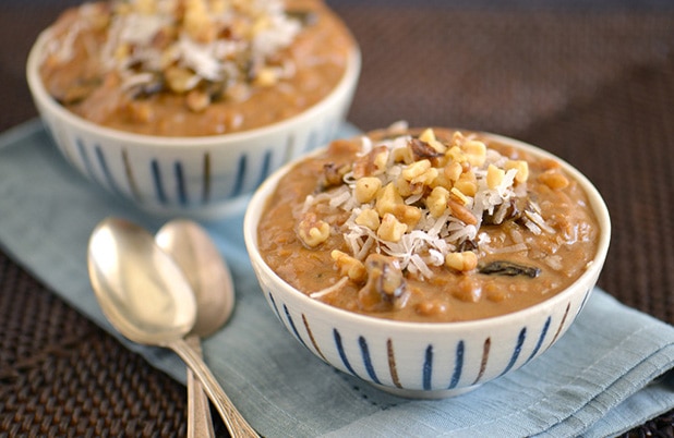 Ceramic bowls of Peruvian Arroz Zambito topped with chopped nuts and shredded coconut.