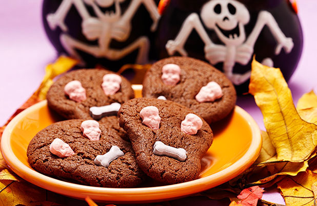 Chocolate cookies shaped like skulls with candy faces.