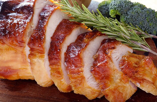 Sliced turkey with bunches of rosemary.