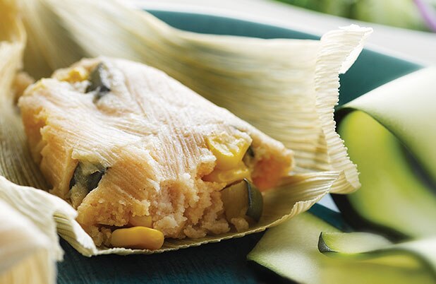 An unwrapped tamale stuffed with corn and zucchini.