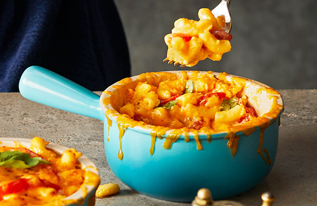 Tomato Basil Mac & Cheese in a blue ceramic bowl on a granite counter.