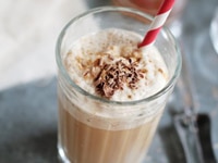 Bebida Blended Vanilla Espresso con un popote rojo y blanco sobre una encimera.