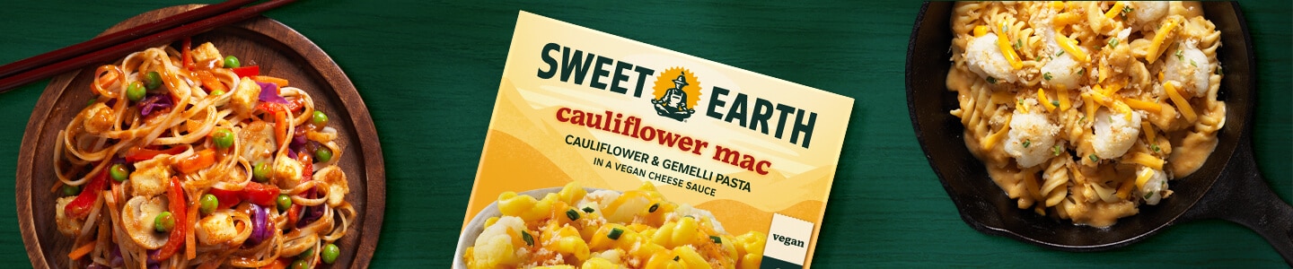 Cauliflower Mac in a skillet, Cauliflower Mac packaging and Pad Thai on a wood plate with chopsticks on a green surface.