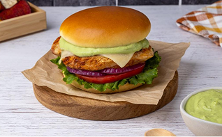 Photograph: chicken sandwich with fried patty, avocado, tomato, red onion, lettuce