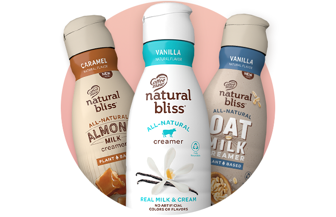 Bottles of natural bliss creamer lined up on a pink circle.