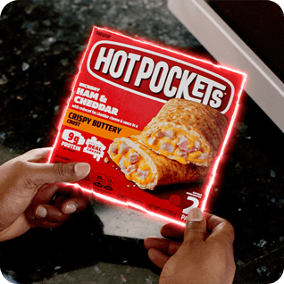 Empaque de Ham & Cheddar Hot Pockets® con una silueta de neón sostenida por manos.