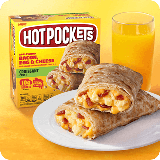 Bacon, Egg & Cheese Hot Pockets® en un plato junto a jugo de naranja y el empaque.