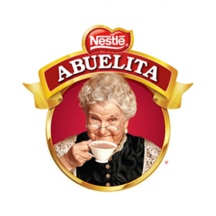 Logotipo de Abuelita con una pancarta en rojo y la abuela bebiendo un taza de chocolate caliente.