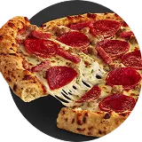 Slice of pepperoni pizza being pulled away from the rest of the pie.