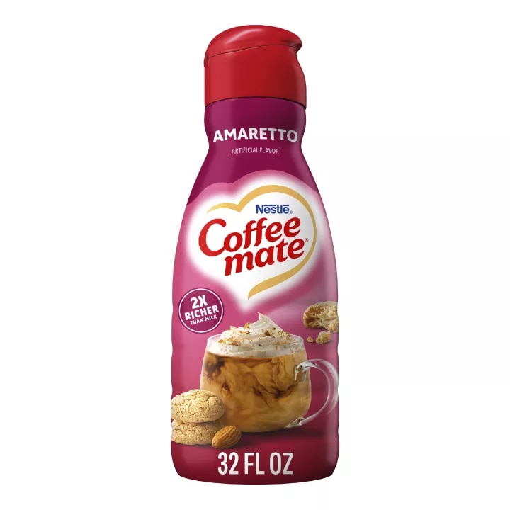 A pink bottle of Amaretto Creamer with amaretto cookies and almonds under the Coffee mate logo.