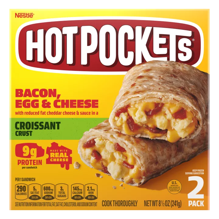 Una caja amarilla de Bacon, Egg & Cheese Hot Pockets con un sándwich con corteza de croissant sobre una etiqueta verde.