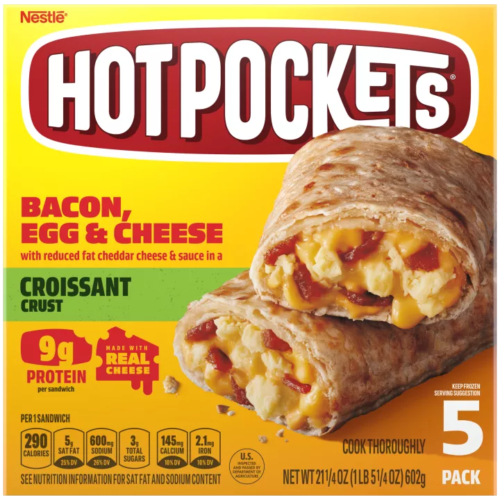 Una caja amarilla de Bacon, Egg & Cheese Hot Pockets con un sándwich con corteza de croissant sobre una etiqueta verde.