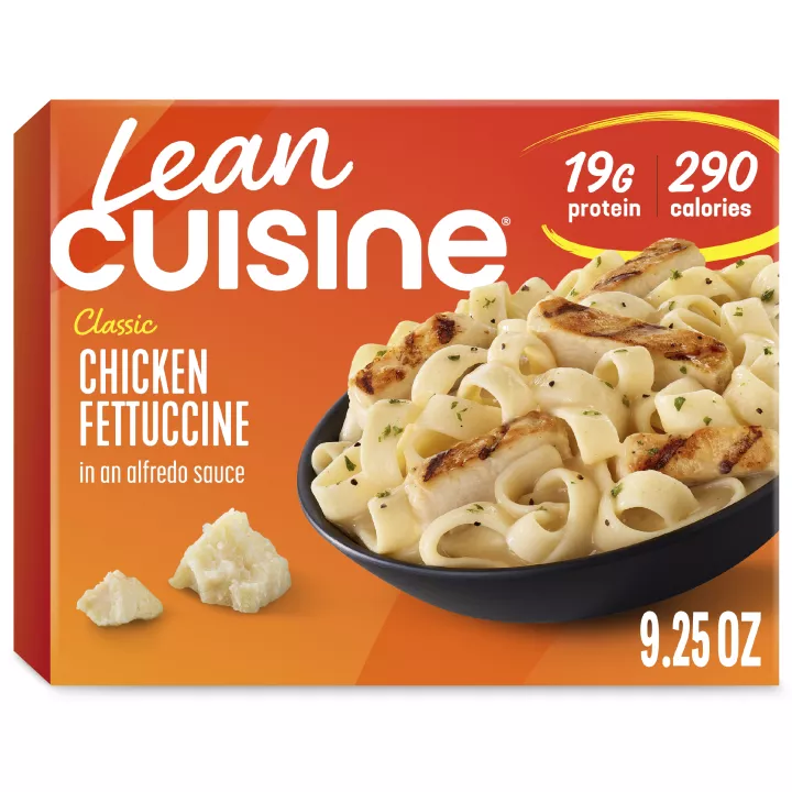 A box of Chicken Fettuccine with a Comfort Cravings label near a bowl of Fettuccine and chicken covered with alfredo sauce.