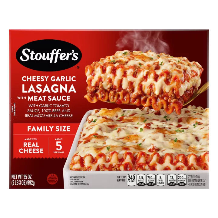 Caja de Cheesy Garlic Lasagna with Meat Sauce con un plato y una fuente de lasaña debajo del nombre del producto y el logo de STOUFFER'S.
