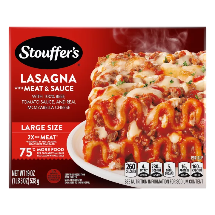 Un plato de Lasagna with Meat & Sauce sobre una mesa debajo del nombre del producto, una etiqueta que dice Tamaño grande y otra que dice "el doble de carne".