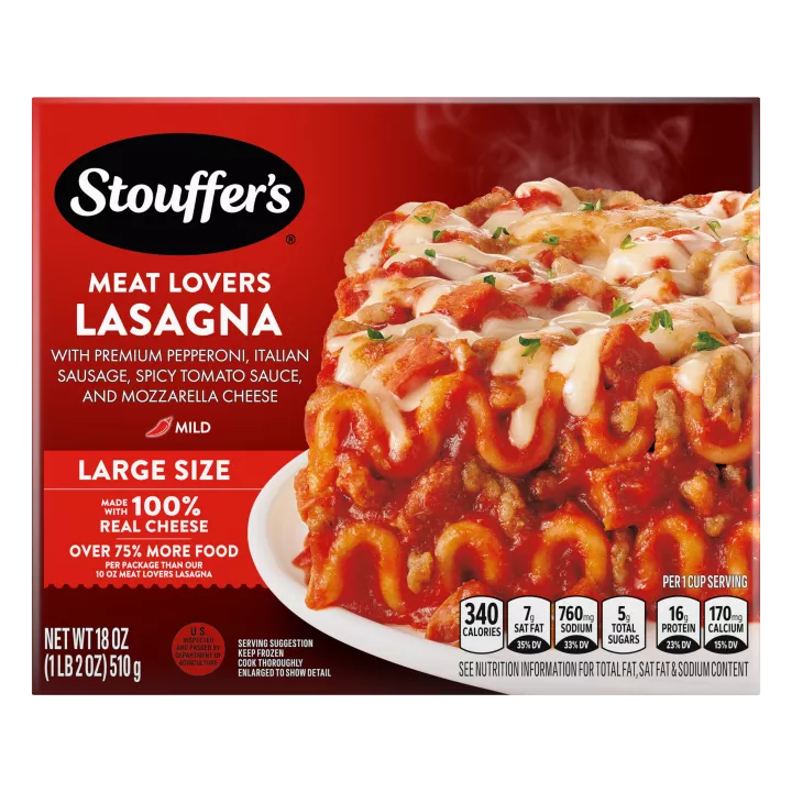 Un plato de Meat Lovers Lasagna sobre una mesa debajo del nombre del producto, una etiqueta que dice tamaño grande, el logo de STOUFFER'S y una etiqueta que dice "17 g de proteína".