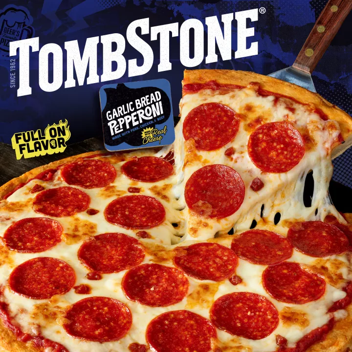 Paquete de garlic bread pepperoni pizza con etiqueta azul y borde, una espátula debajo de una pizza y el logo de Tombstone.