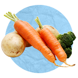 Close up of vegetable in a pile, carrots, broccoli, mushrooms, on a blue background.