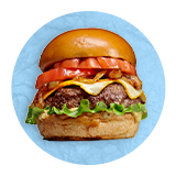 Close up of a big bacon cheeseburger with lettuce and tomato on a blue background.