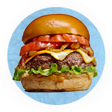 Close up of a juicy bacon cheeseburger, on a blue background.