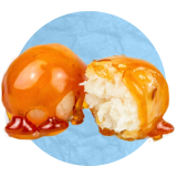 Primer plano de un par de manzanas acarameladas sobre un fondo azul.