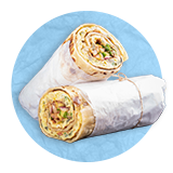 Close up of a sandwich wrap wrapped in white deli paper sliced in half one half leaning on the other. on a blue background.