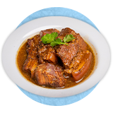 Close up of pork stew and a scoop of rice in a white bowl, on a blue background.