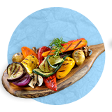  Primer plano de una cuchara de madera llena de vegetales asados picados sobre un fondo azul.