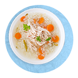 Plano aéreo de un tazón de caldo de pavo sobre un fondo azul.