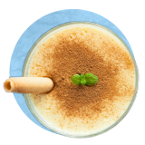 Primer plano aéreo de una natilla con canela por encima sobre un fondo azul.