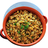 Una olla holandesa llena de relleno guatemalteco sobre un círculo naranja.