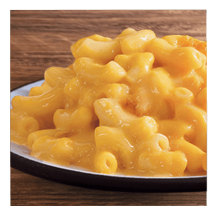 Macaroni and cheese on a white plate and wooden table top.