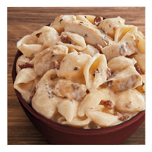 Chicken Bacon Ranch Pasta in a white bowl on a wooden table top.