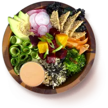 Overhead of a macro bowl with raw veggies, rice, and tahini dressing.