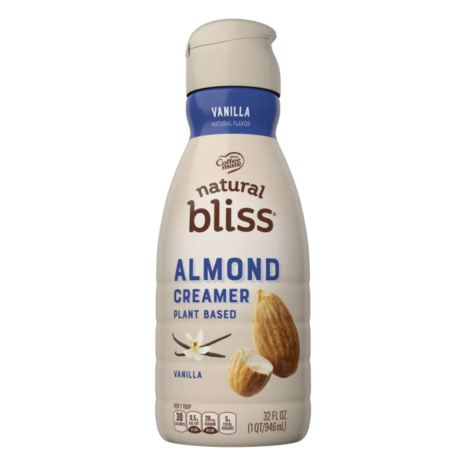 Una botella beige de creamer natural bliss Vanilla Almond Milk con una etiqueta azul encima de vainas de vainilla.