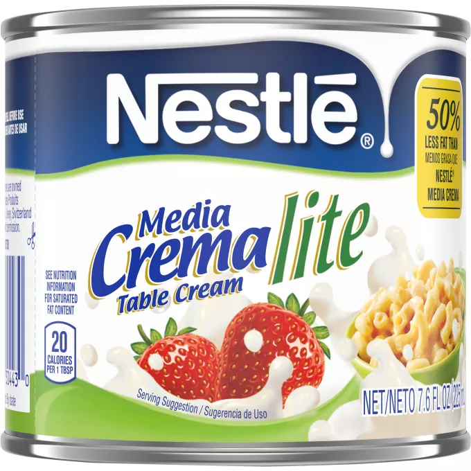 Una lata de crema ligera que muestra el logo de Nestlé sobre una etiqueta azul con un derrame en color blanco por encima del logo de Media Crema, fresas que caen sobre la crema y la salpican y un tazón de macarrones con queso sobre un remolino verde claro.