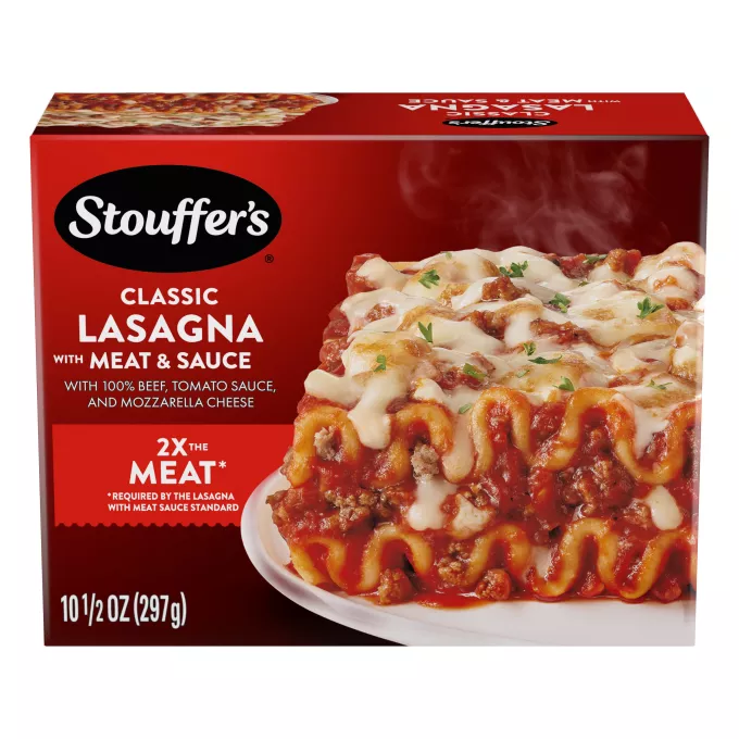 Un plato de Lasagna with Meat & Sauce sobre la mesa debajo del nombre del producto, el logo de STOUFFER'S y una etiqueta que dice "el doble de carne".