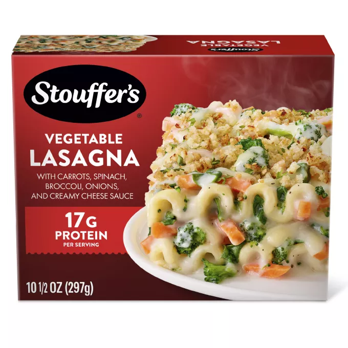 Caja de Veggie Lovers Lasagna con un plato de lasaña sobre una mesa debajo del nombre del producto y del logo de STOUFFER'S.