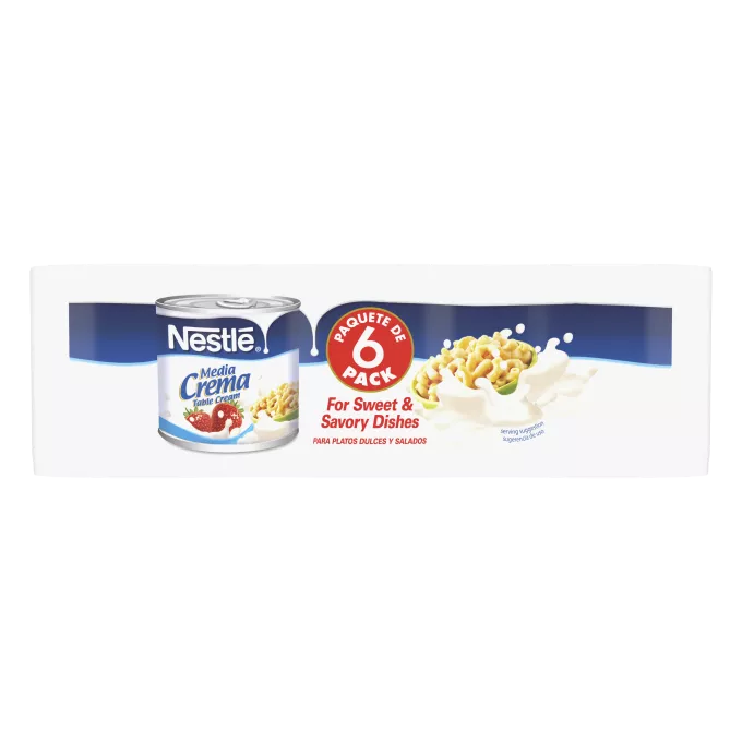 Una lata de crema de mesa que muestra el logo de Nestlé sobre una etiqueta azul con un derrame en color blanco por encima del logo de Media Crema, fresas que caen sobre la crema y la salpican y un tazón de macarrones con queso sobre un remolino azul claro.