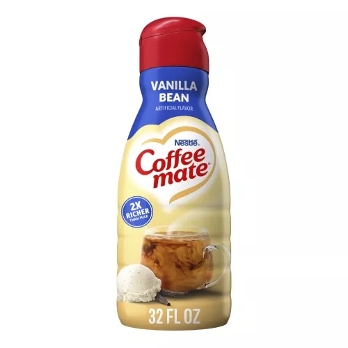 A bottle of Vanilla Bean creamer with a blue label above a blue mug and a bowl of vanilla ice cream next to a vanilla bean.