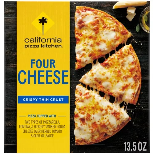 Box of Four Cheese Pizza with half a pizza, oil and blocks of parmesan on a black wooden surface.