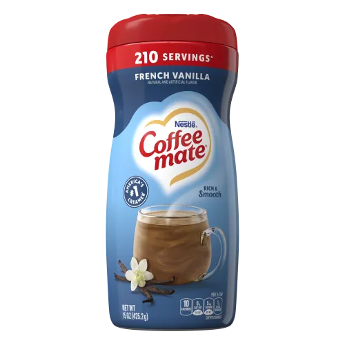 Una lata azul de creamer en polvo Coffee mate French Vanilla con una gorra roja encima de una taza de café y vainas de vainilla.