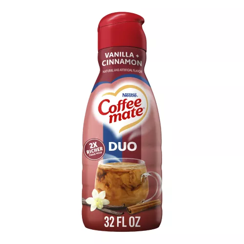 Una botella roja de creamer Cinnamon Vanilla Crème con una taza de café y ramas de canela debajo del logotipo de Coffee mate.